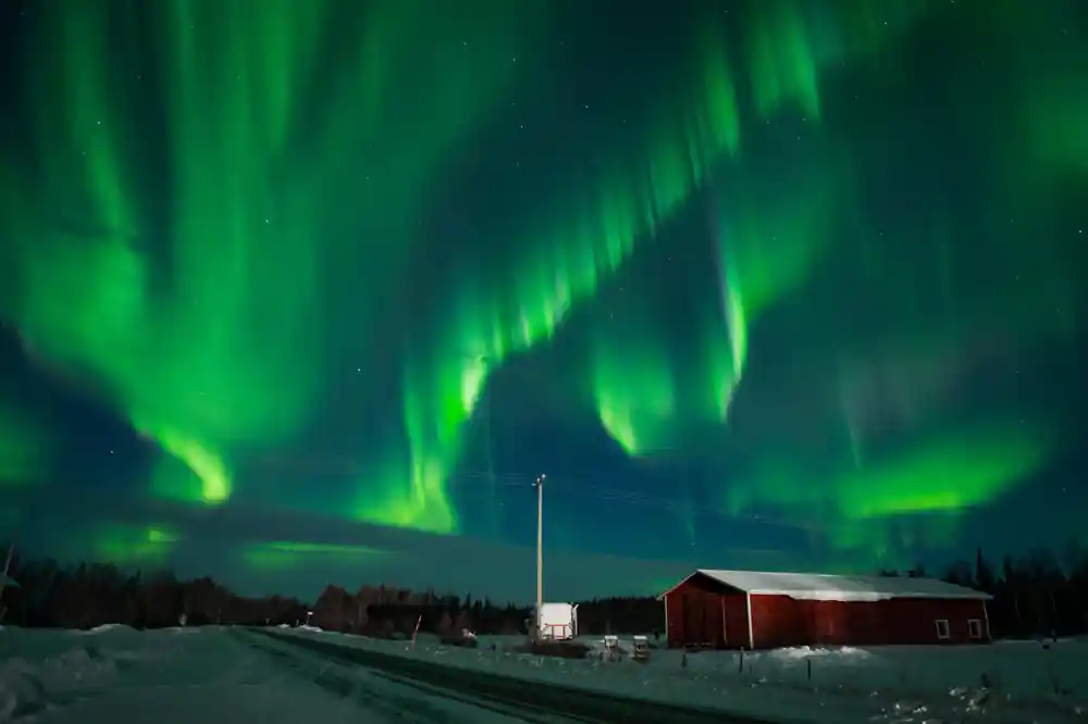 Aurora borealis over rural house in winter