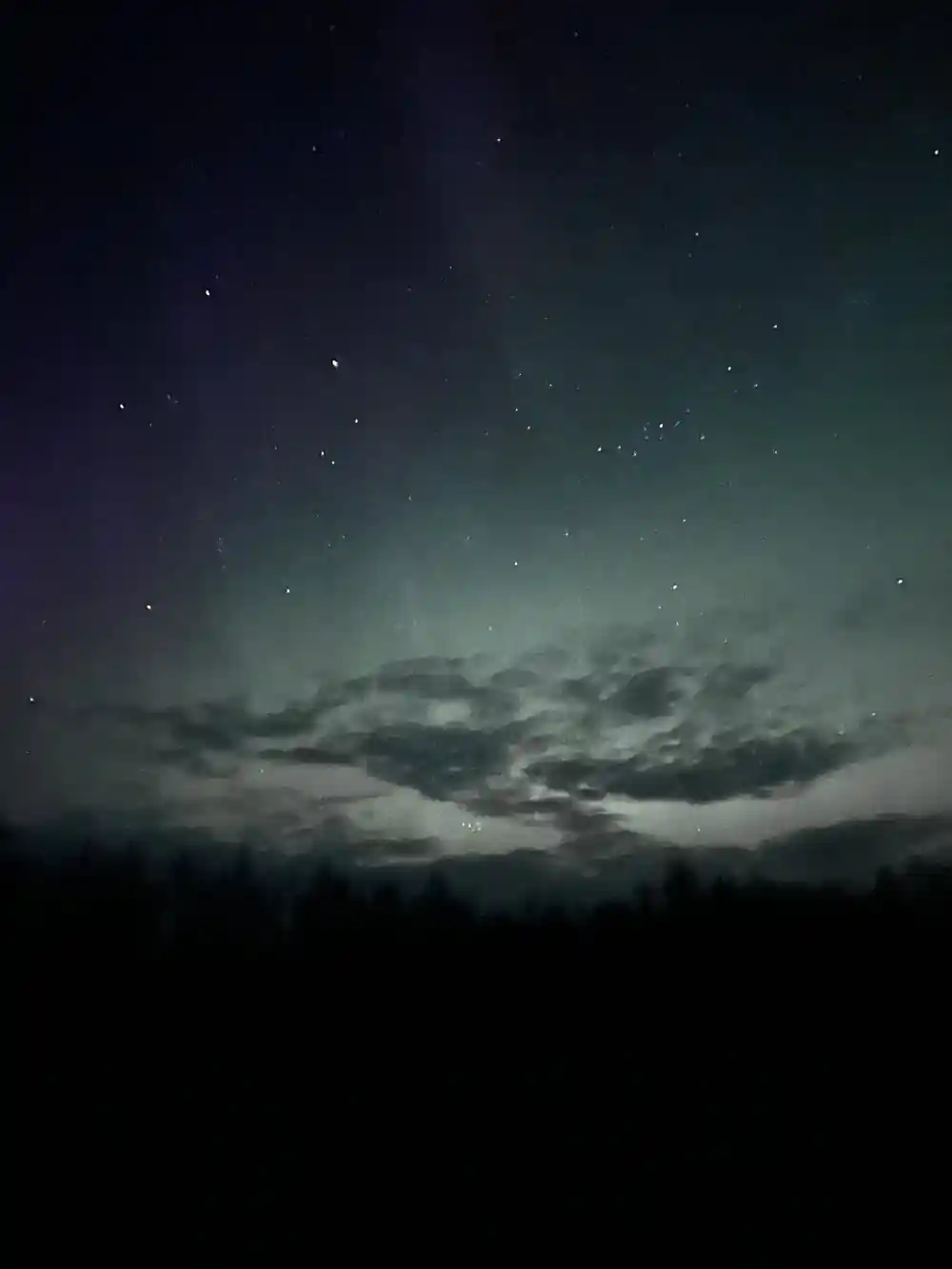 Aurora borealis and stars above cloudy horizon landscape